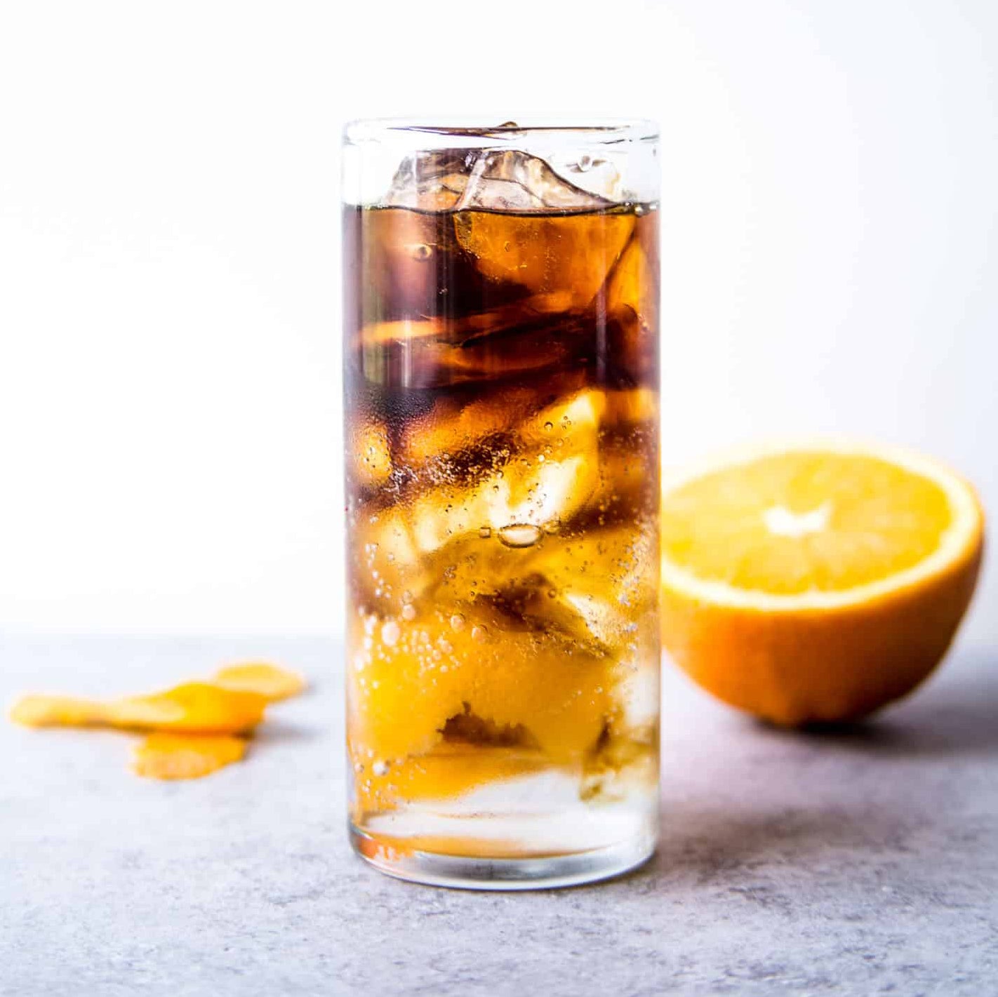 espresso tonic in tall glass using BLK MGK espresso hemp spirit with half an orange in the background