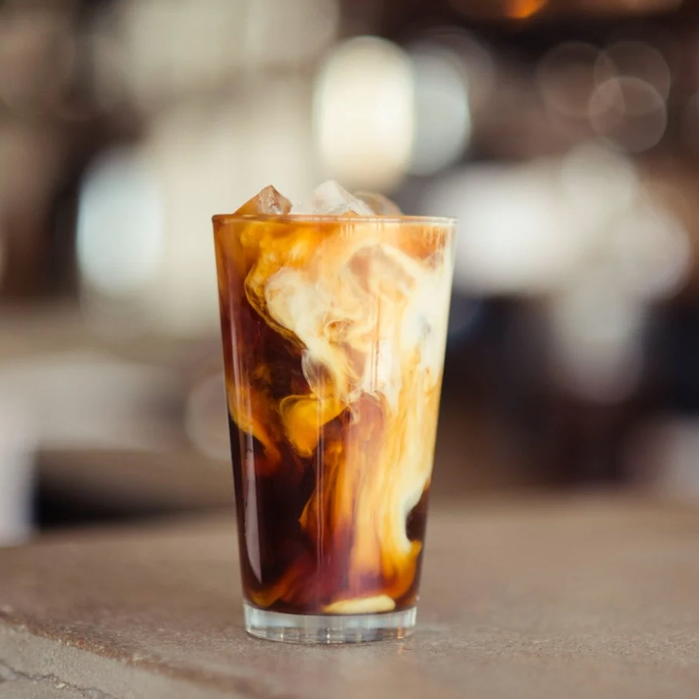 creamy coffee drink using BLK MGK espresso hemp spirit sitting on table