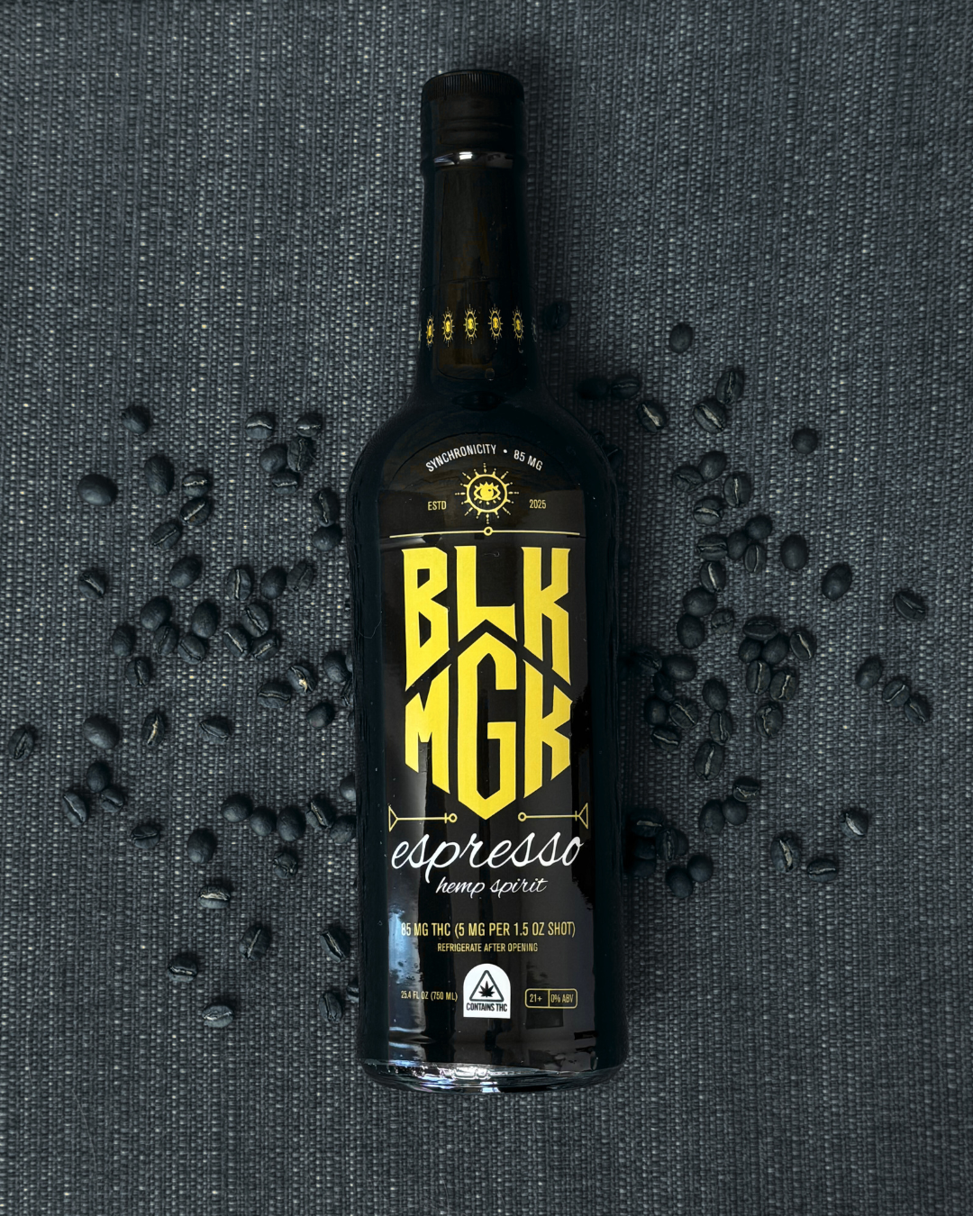 BLK MGK Espresso hemp spirit bottle with scattered coffee beans on a textured black and white background