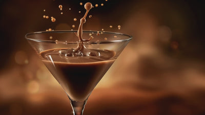 slow motions video of a splash and droplets into an espresso martini with warm lighting 